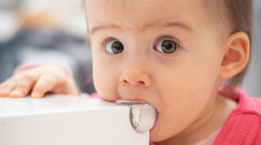Baby mouthing on corner of table