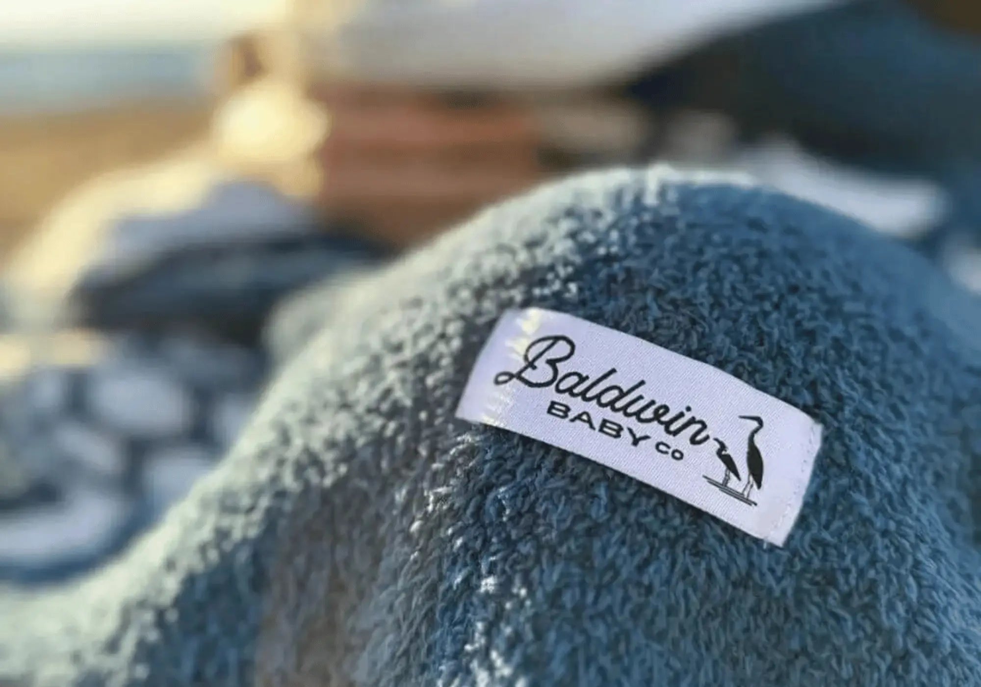 close up of Baldwin Baby Co label on a blue baby blanket with white turtles