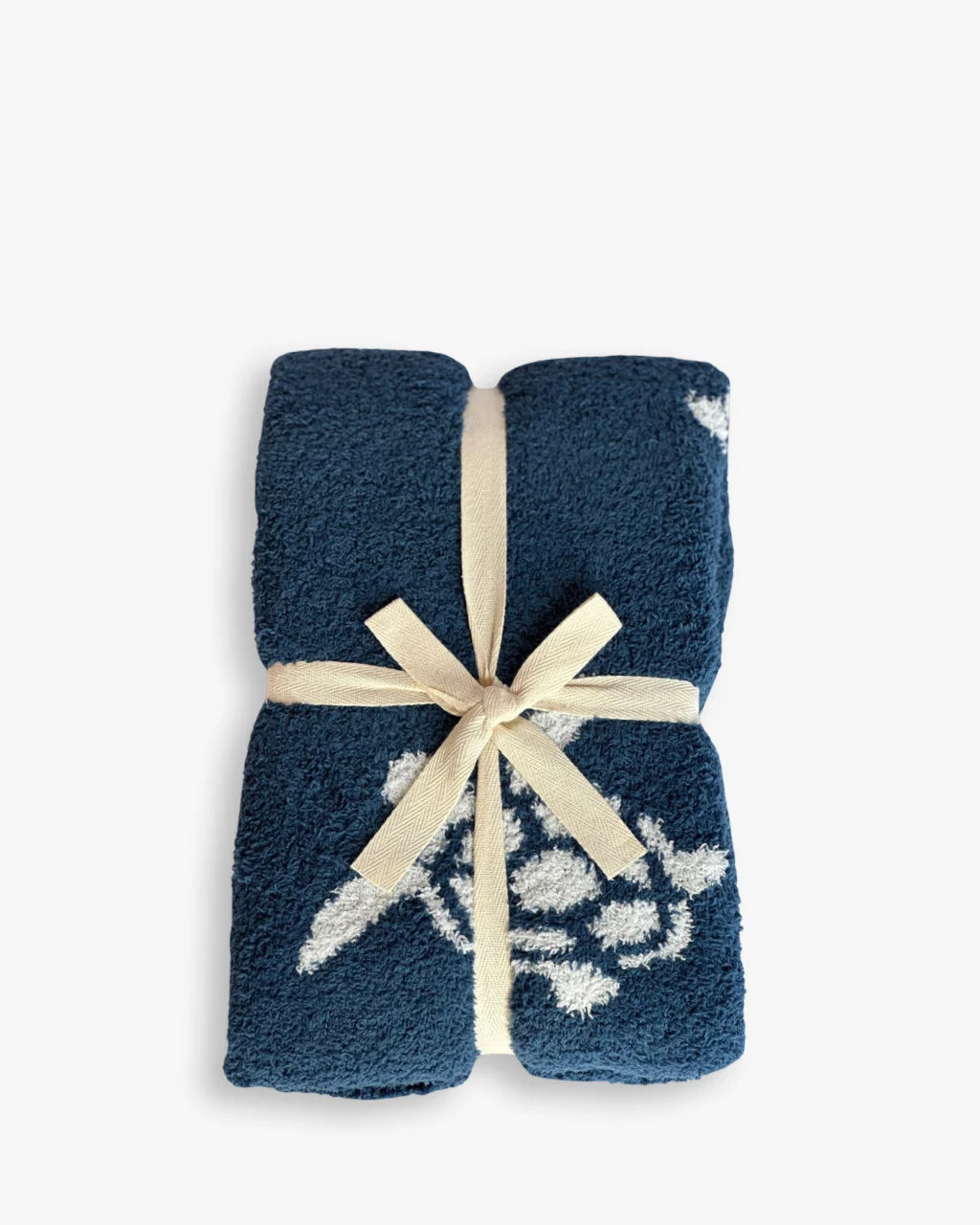 Blue and white Sea Turtle Blanket folded with cream ribbon, perfect for baby gifting