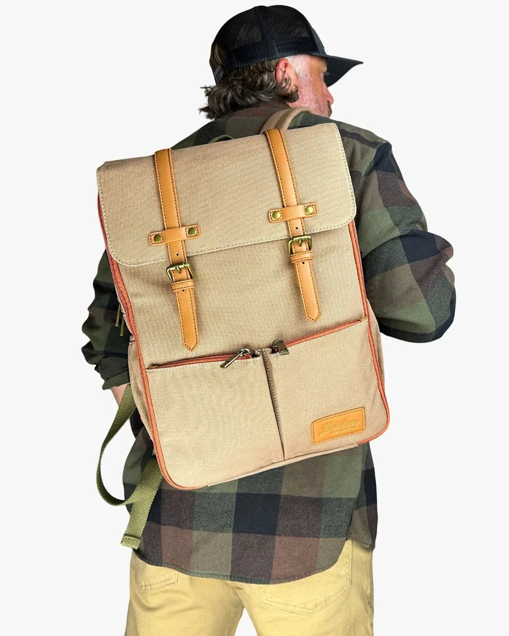 Man wearing beige canvas diaper backpack at angle, showing stylish, versatile design