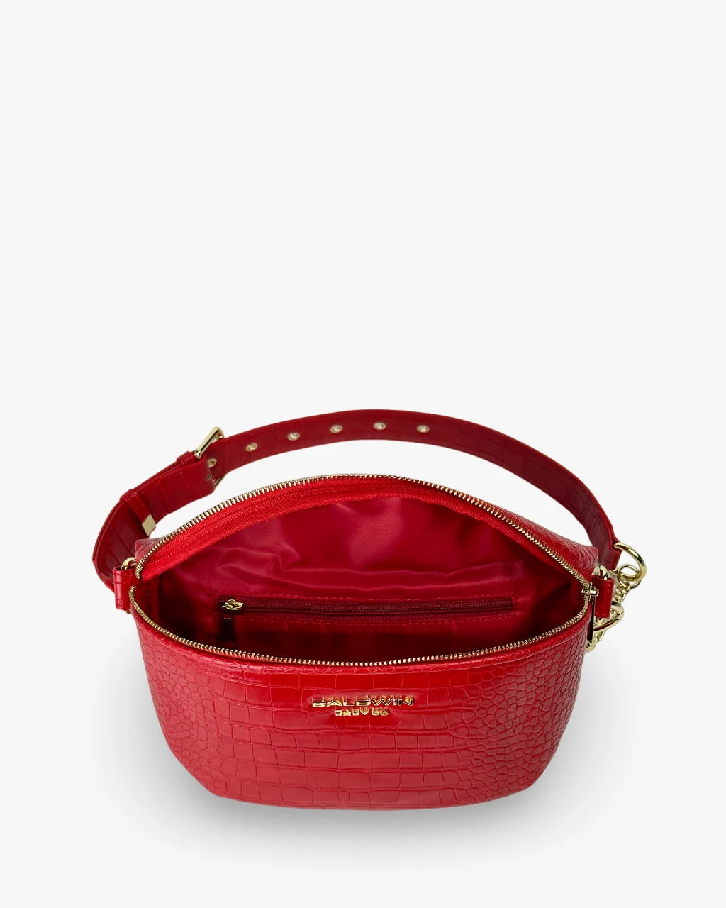 Interior of red faux croc belt bag with red satin lining and zippered pocket