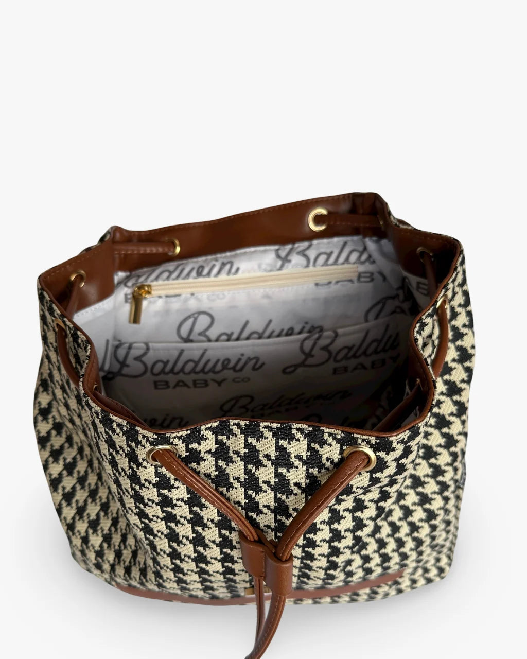 Angled view of houndstooth diaper backpack interior with drawstring and storage pockets