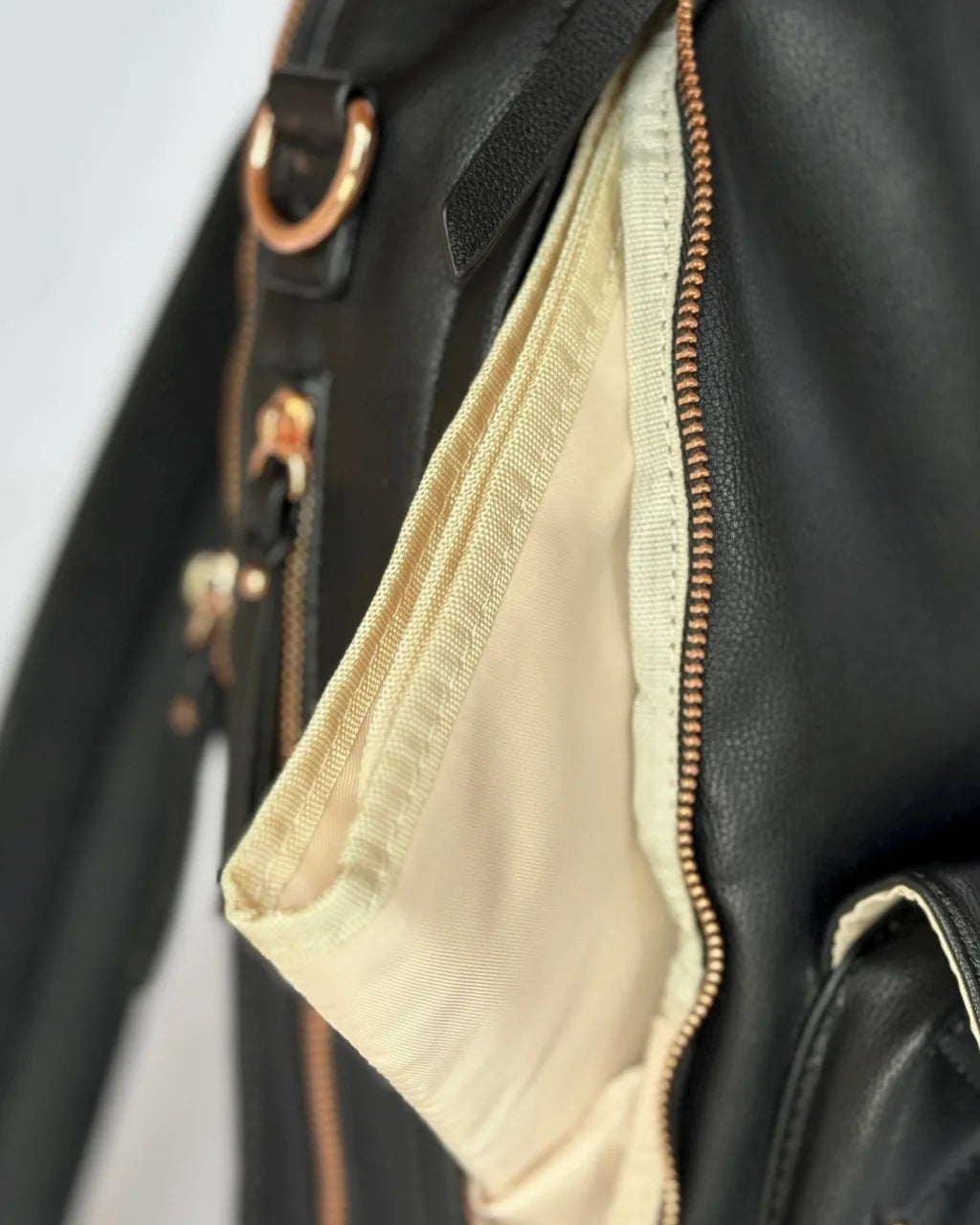 Close-up of the cream changing pad included with the black diaper bag, offering convenient functionality for parents on the go.