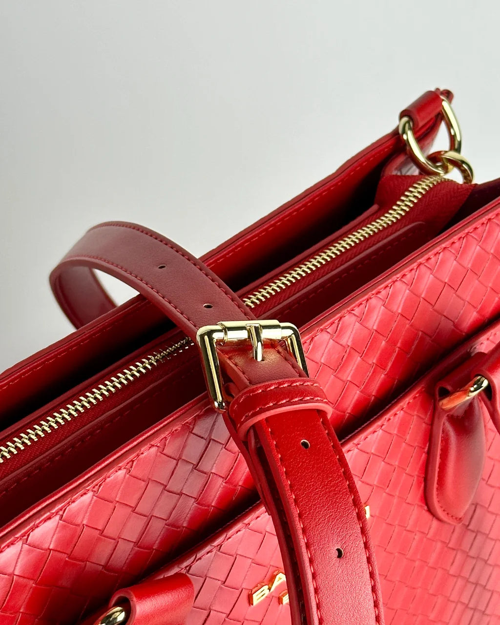 Highlighting the elegant gold hardware details and vibrant red quilted texture of the Cardinal Montrose diaper bag.