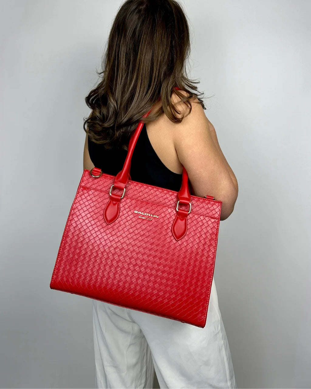 Cardinal red diaper tote worn over shoulder, showing stylish versatility and roomy design
