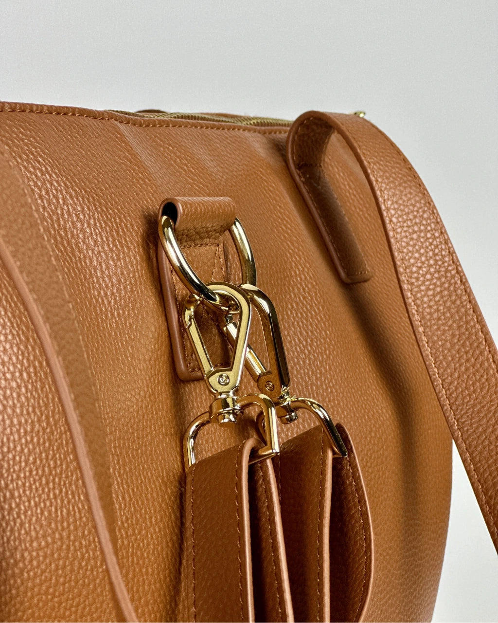Close up view of vegan brown leather diaper bag with gold hardware