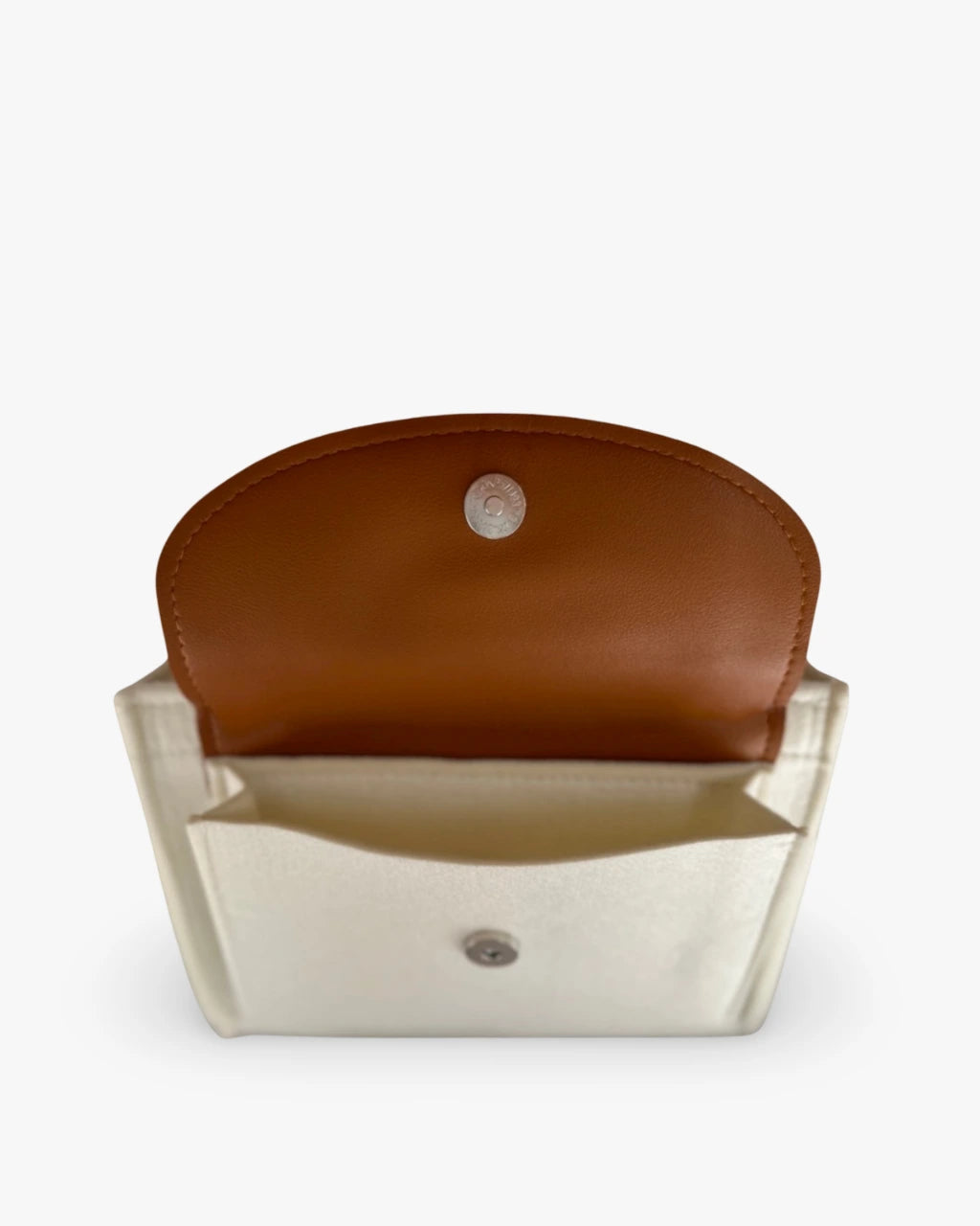 side view of a creamy white diaper caddy made of felt displaying open pocket with leather flap