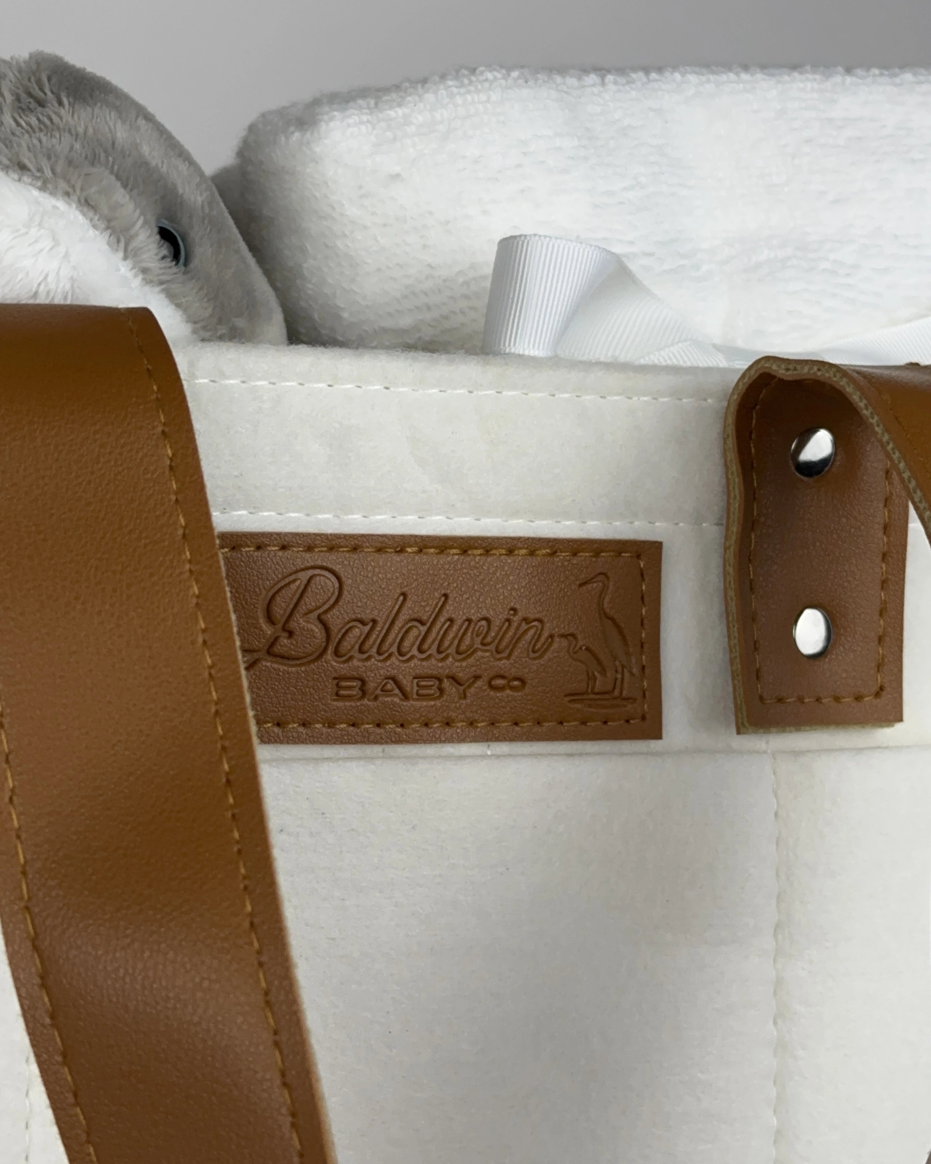 White felt diaper caddy with brown leather handles and accents