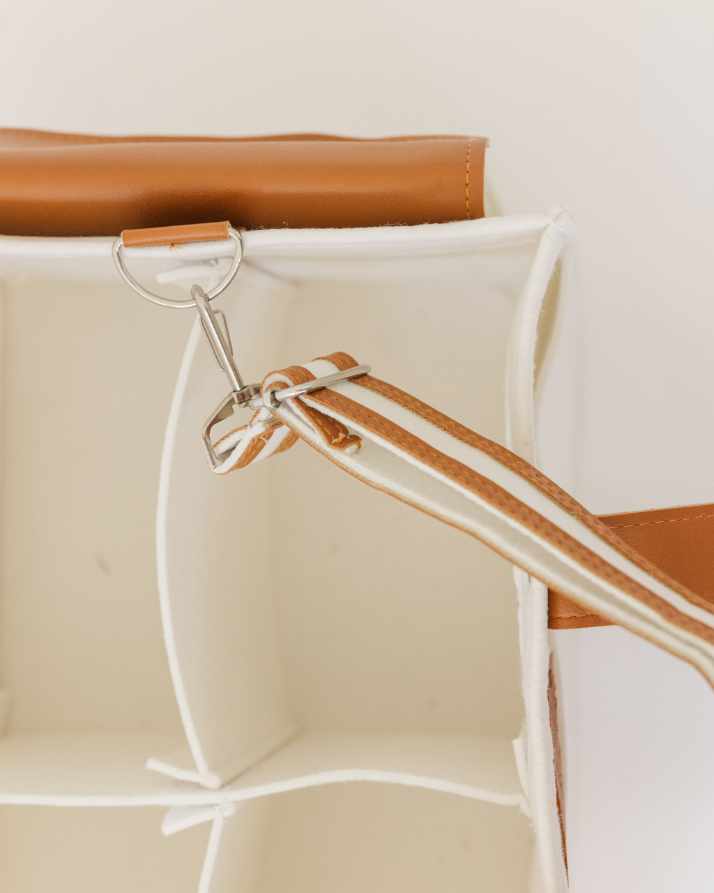 White felt diaper caddy with brown leather handles and accents