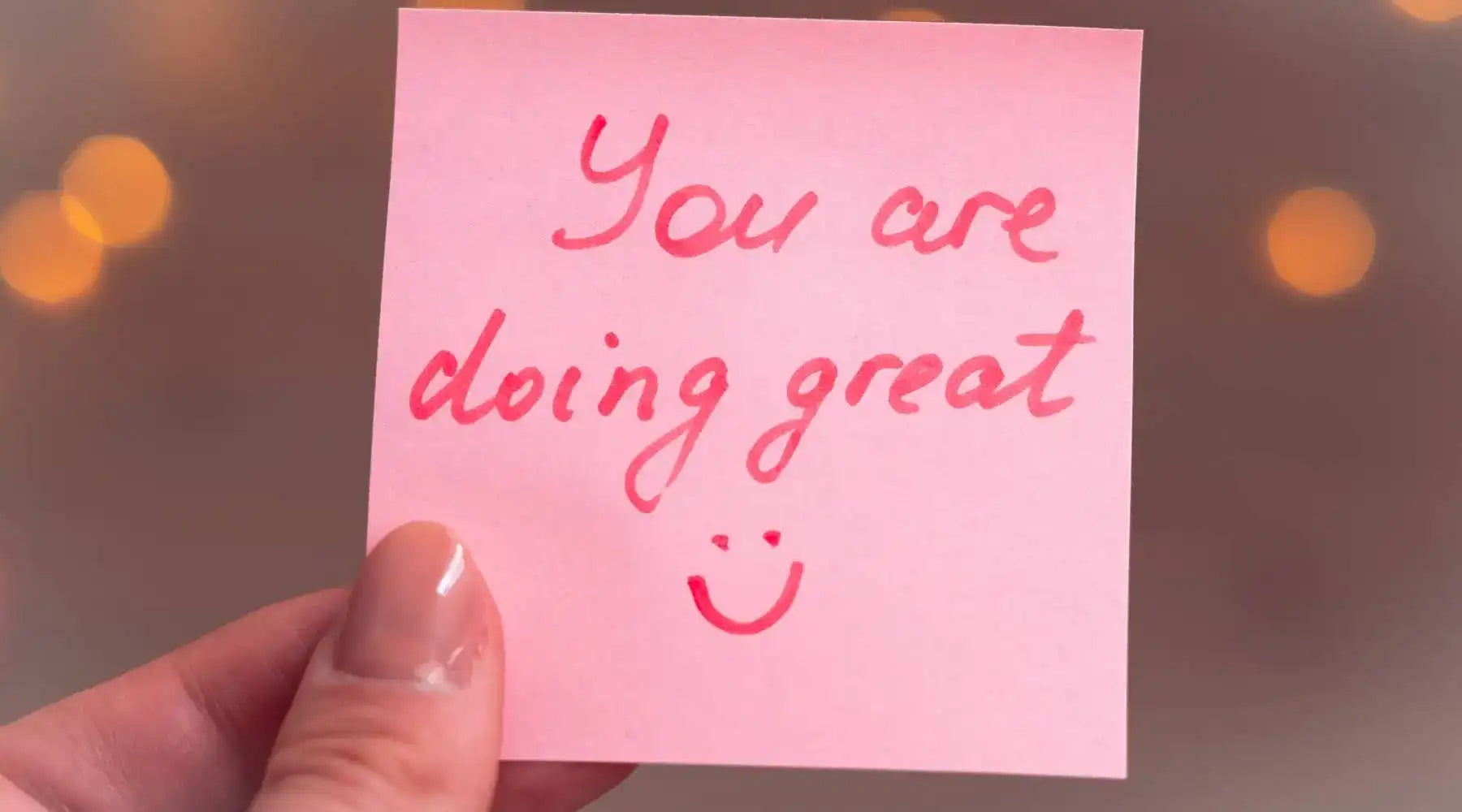 Pink sticky note reading “You are doing great” offers encouragement and positive affirmation support