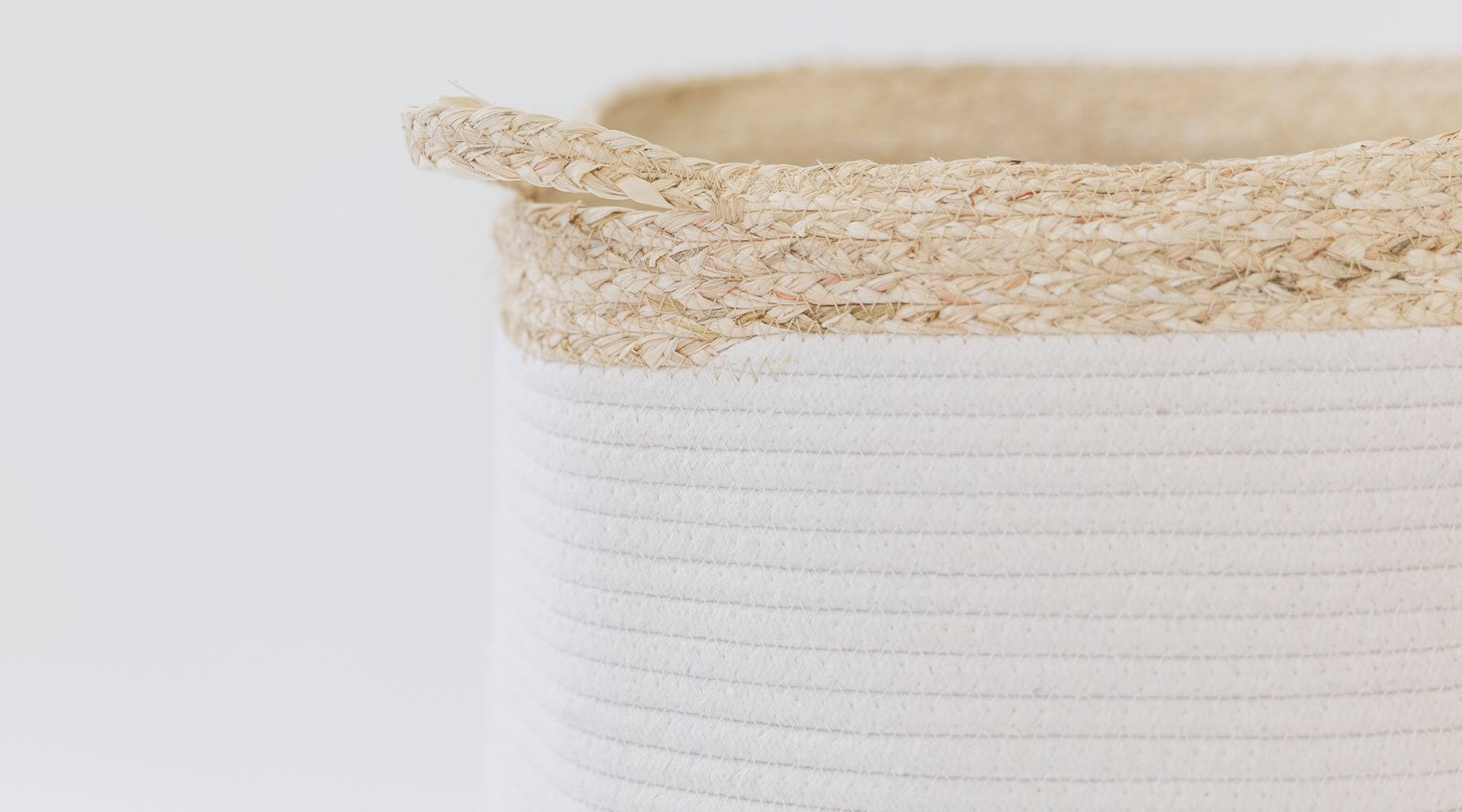 white bell shaped rope basket with corn husk details and handles