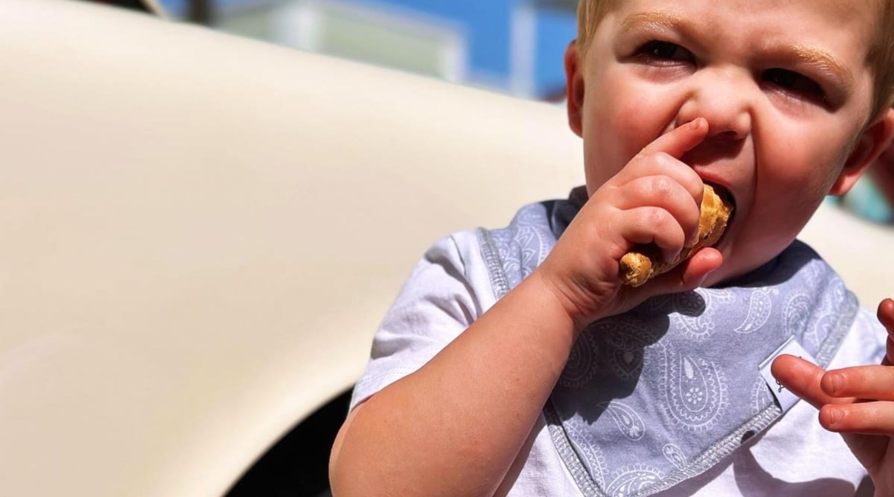 toddler wearing a bib eating an ice cream cone