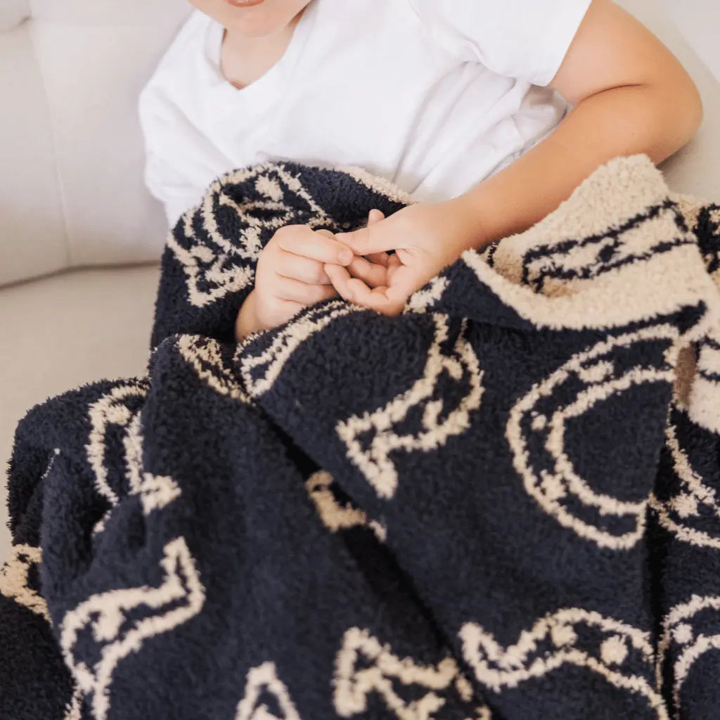 black and tan horseshoe blanket in the lap of a child