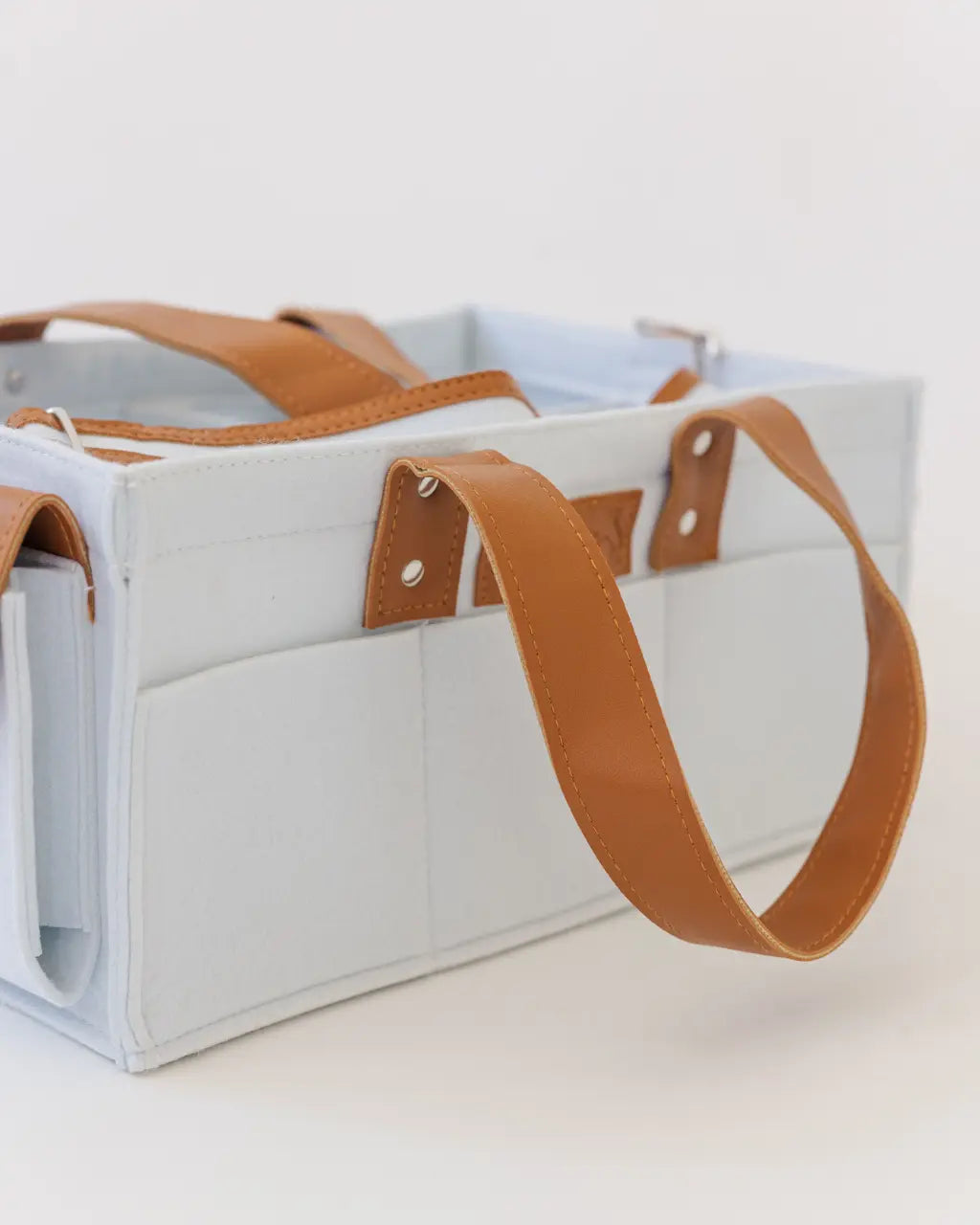 Light blue felt diaper caddy with brown leather handles and accents