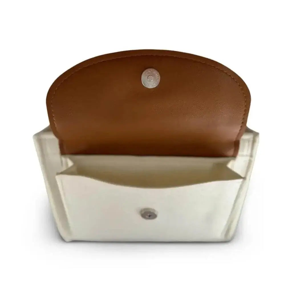 side view of a creamy white diaper caddy made of felt displaying open pocket with leather flap