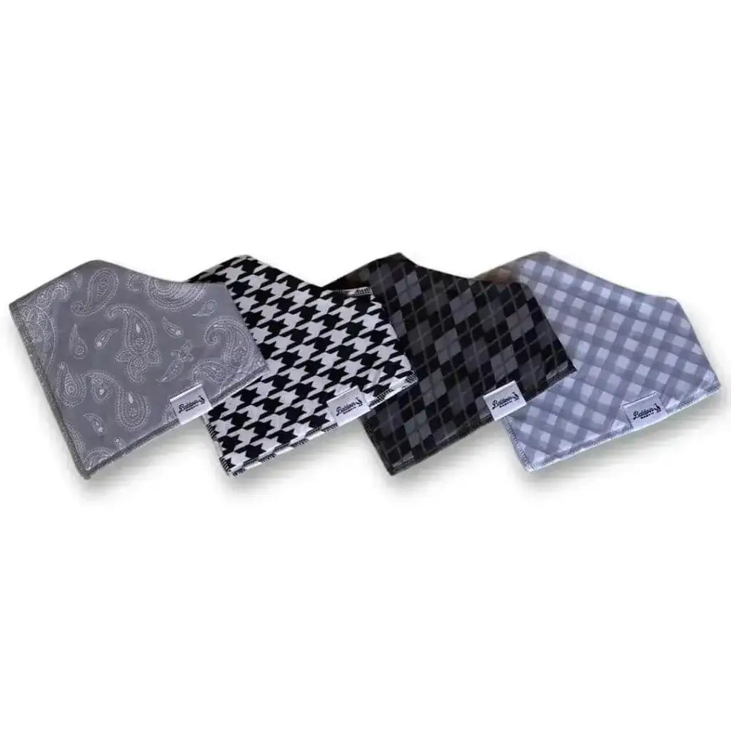 Set of four bandana bibs on a white background. Gray with white paisley, traditional white and black houndstooth, grayscale plaid or argyle, and timeless gray and white checkered patterns