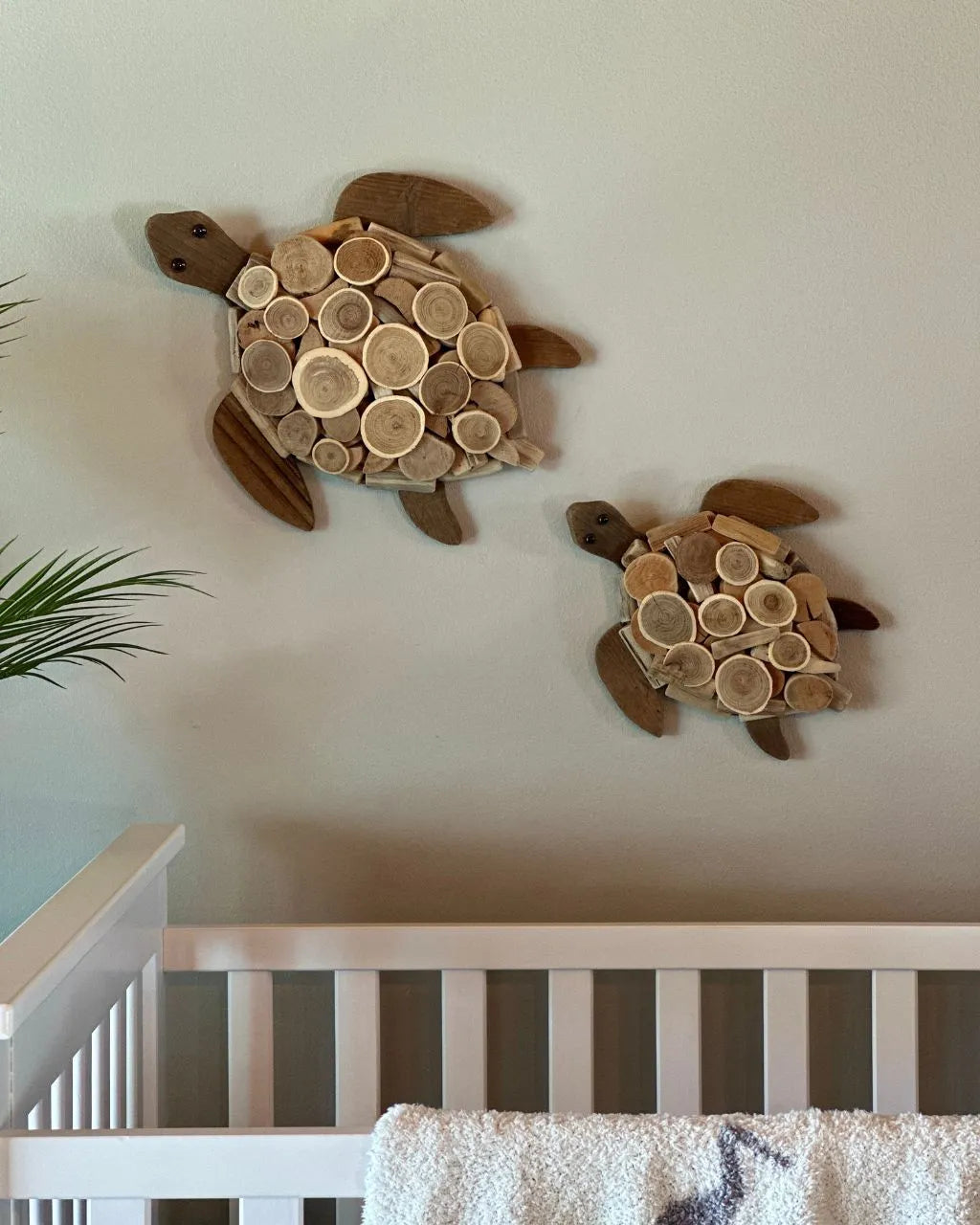 Set of two wooden sea turtle wall decor displayed over crib